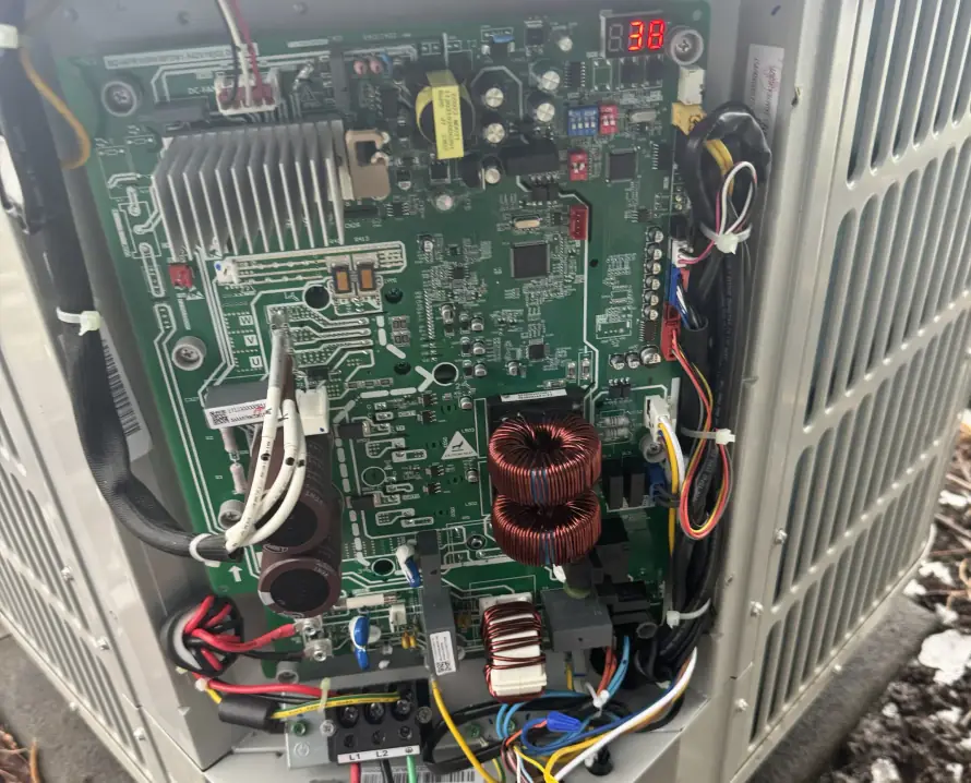 Heat pump with its inverter control board exposed for repair