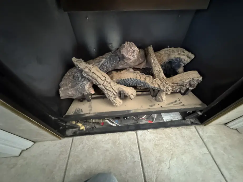 Gas fireplace with the front removed, log set and burner exposed for service