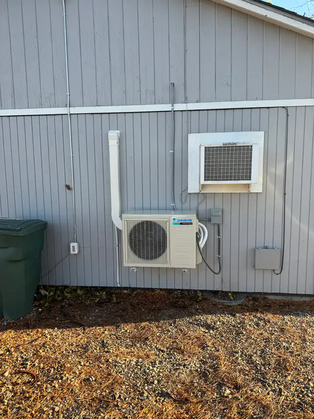 Daikin ductless outdoor unit mounted on grey siding